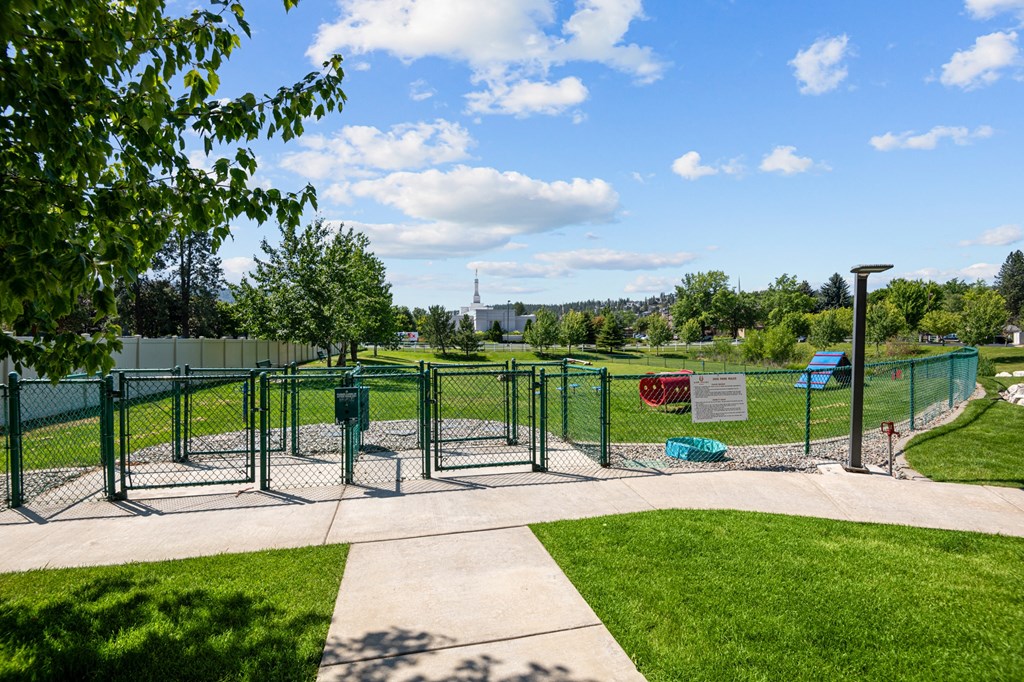 a fenced in area of a park with playground equipment