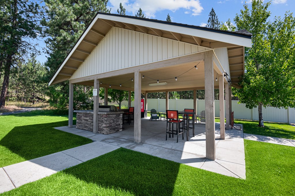 a covered patio with a table and chairs under a pavilion