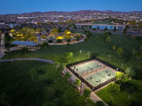 an aerial view of a tennis court with a city in the background