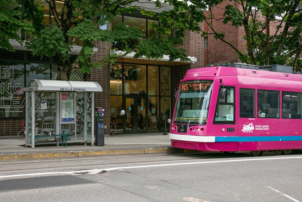 a pink bus is parked on the side of a street