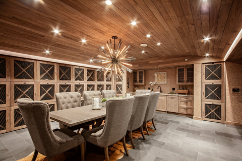 a wine tasting room with a long table and chairs and a kitchen