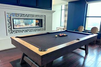a pool table in a living room with a fireplace