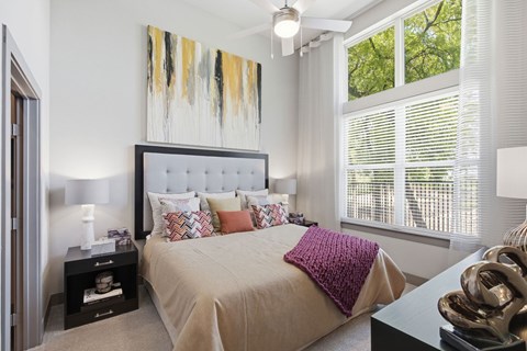A bedroom with a large bed and a painting above it.