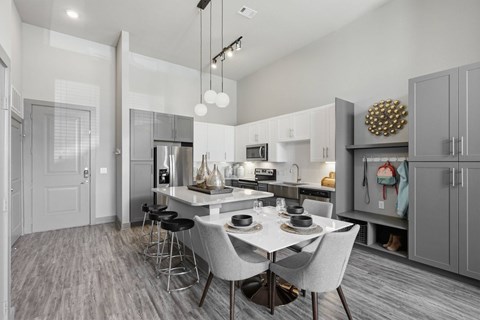 A modern kitchen with a dining table and chairs.