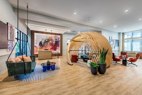 the lobby of a hotel with a large pod in the center
