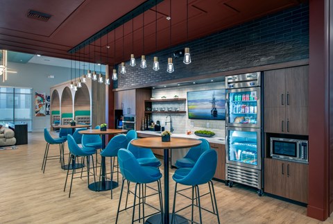 the lobby of a restaurant with blue chairs and a bar