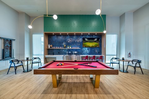 a pool table in a room with a bar and tables