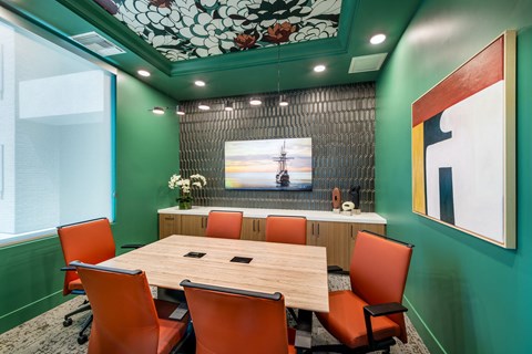 a conference room with a wooden table and orange chairs