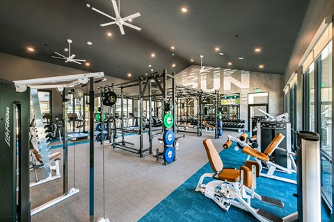 a gym with weights and cardio equipment and a sign on the wall