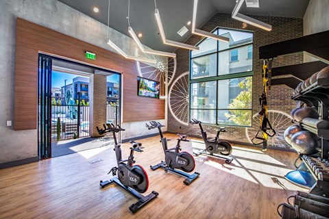 a gym with exercise bikes and a view of a building