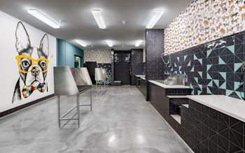 a public restroom with a dog painting on the wall