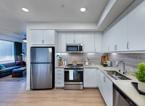 a kitchen with white cabinets and a stainless steel refrigerator