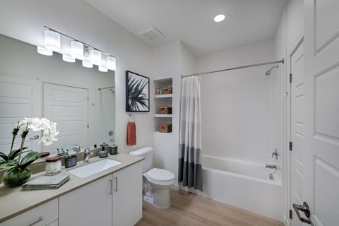 a bathroom with a shower and a sink and a toilet