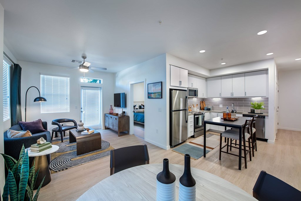 an open living room and kitchen with a table and chairs