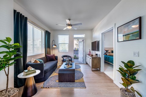 a living room with a couch and a coffee table and a ceiling fan