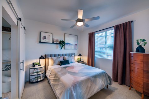 a bedroom with a bed and a ceiling fan