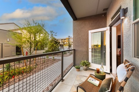 a balcony with a couch and a chair and a fence