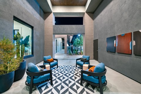 a lobby with blue chairs and a geometric rug