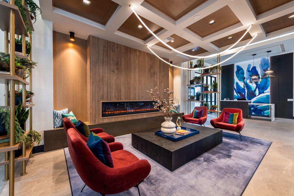 a living room with red chairs and a fireplace