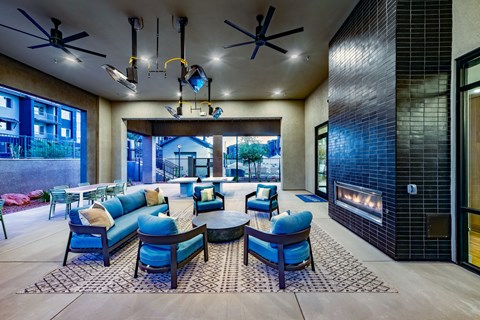 a lobby with blue chairs and couches and a fireplace