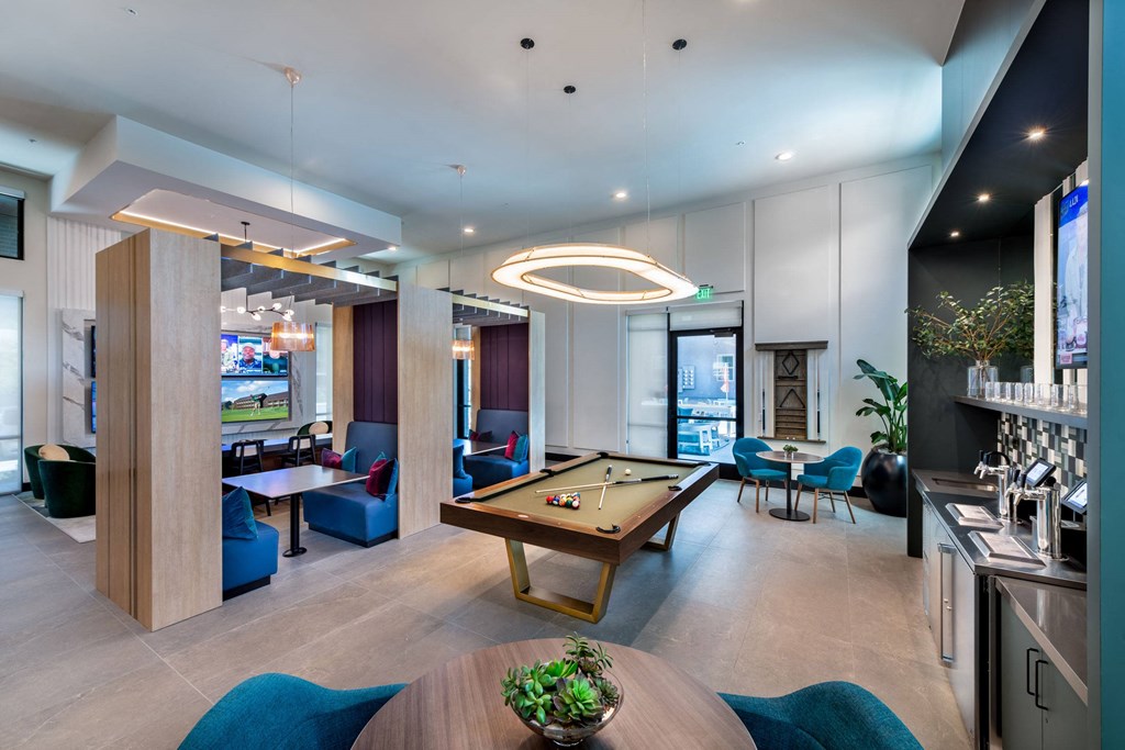 a lounge area with a pool table and a bar