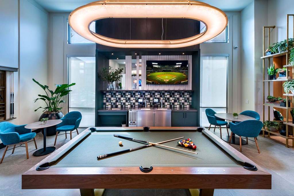 a pool table in a room with a bar and a television