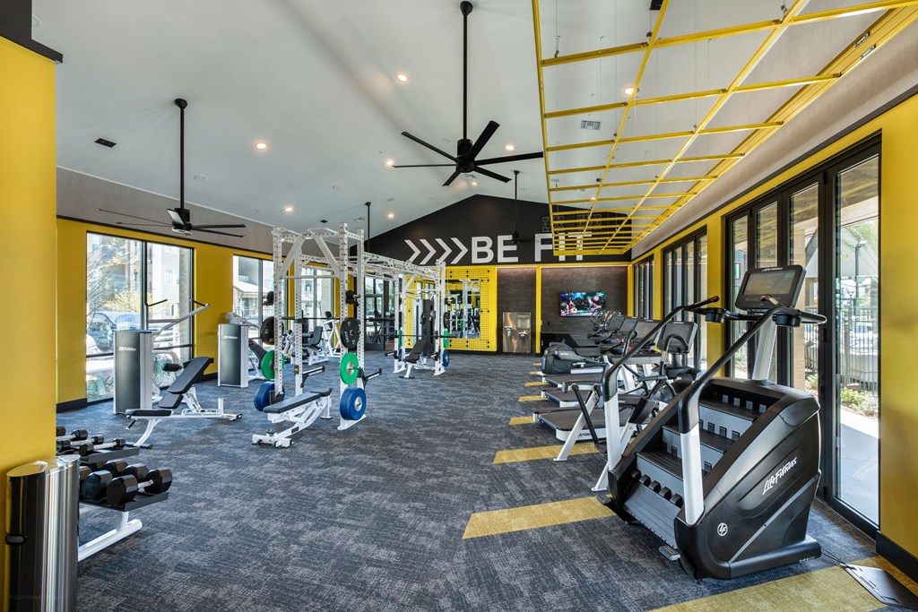 a gym with treadmills and other exercise equipment in the lobby of a building