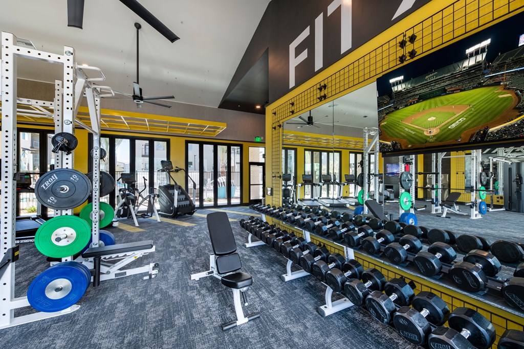 a gym with weights and a football scoreboard on the wall