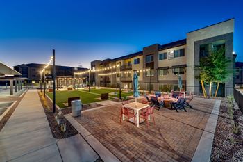 an outdoor patio with tables and chairs at night