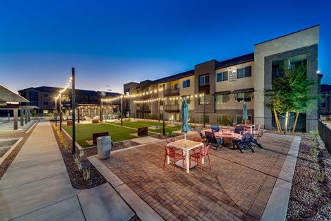 an outdoor patio with tables and chairs at night