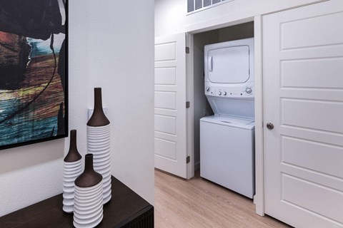 a white washer and dryer in a room with a door to a bathroom