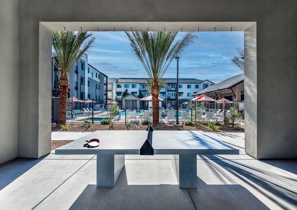 a ping pong table in a courtyard with palm trees