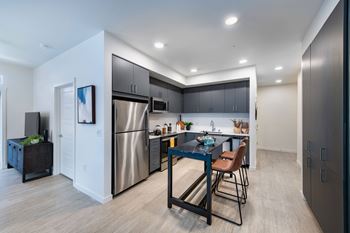 a kitchen with stainless steel appliances and a table with chairs