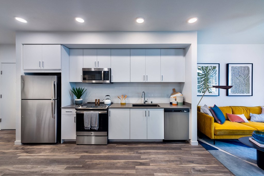 a kitchen with white cabinets and a stainless steel refrigerator