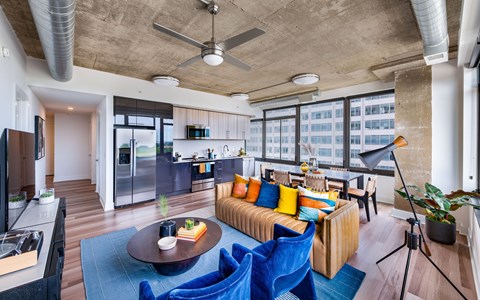 A living room with a blue couch and a ceiling fan.