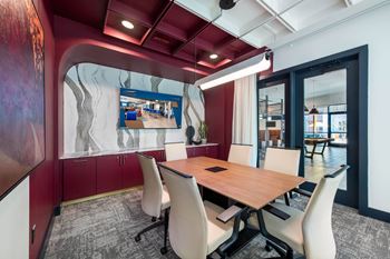 a conference room with a table and chairs and a tv