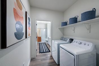 a washer and dryer in a laundry room with a door to a hallway