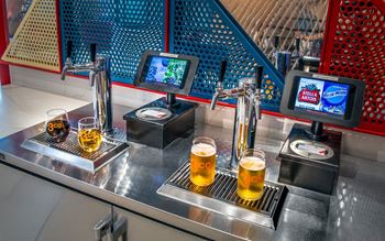 Two beer taps with glasses of beer in front of them.