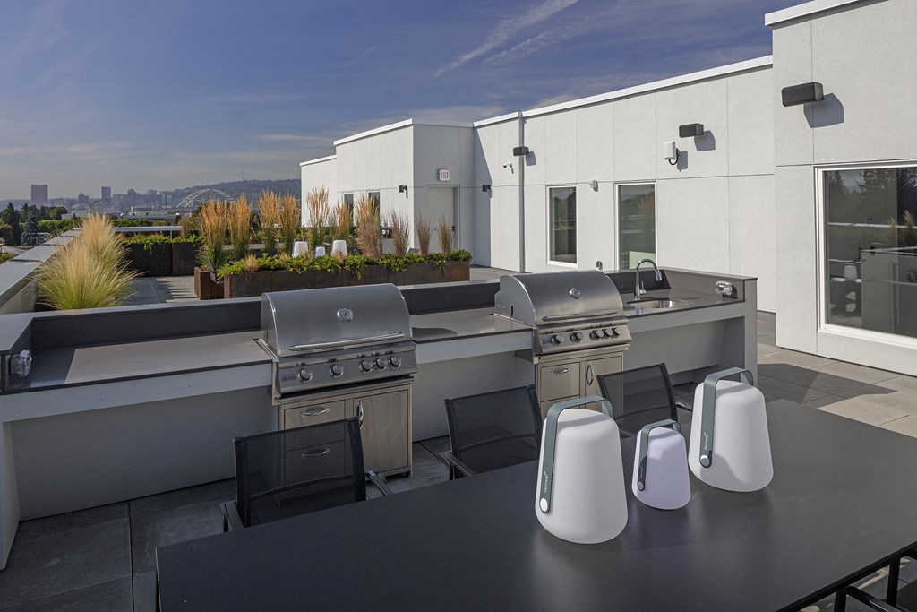 an outdoor kitchen with stainless steel appliances and a black table