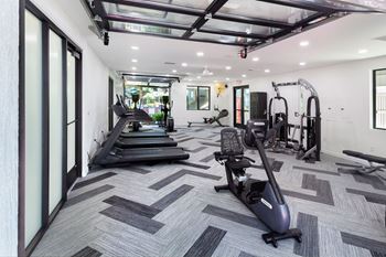 a workout room with treadmills and other exercise equipment