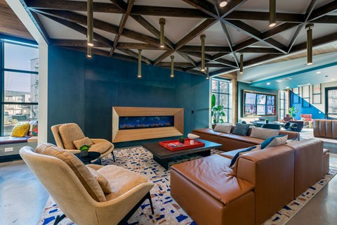 a living room with blue walls and leather furniture and a fireplace