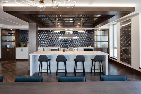 a large kitchen with a white counter top and bar stools