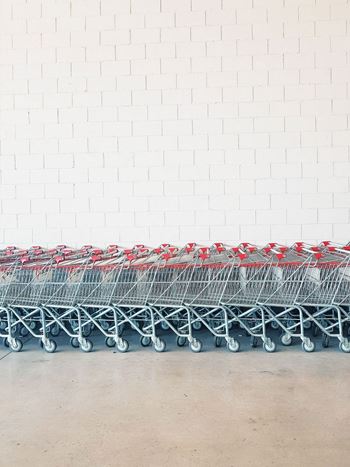 a row of shopping carts in front of a white brick wall