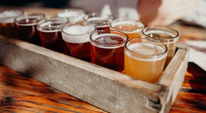 a wooden box filled with different types of beers