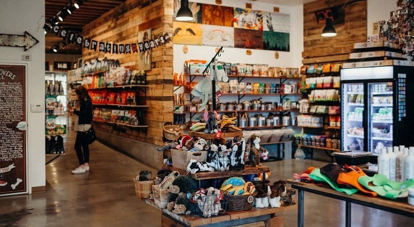 a woman walking into a store with a display of shoes