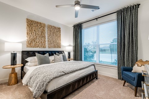A bedroom with a large bed and a ceiling fan.