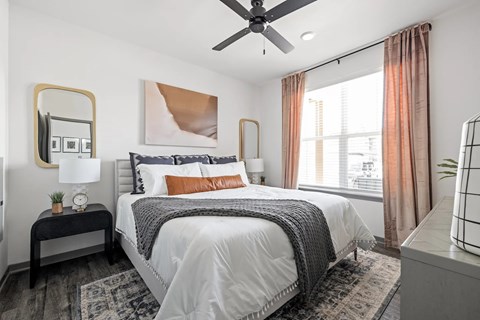 A bedroom with a large bed and a ceiling fan.