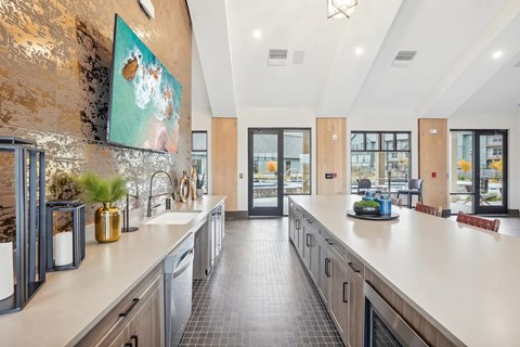 A modern kitchen with a long counter and a painting hanging above it.