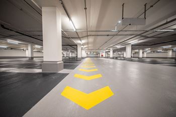 a parking garage with yellow arrows on the floor