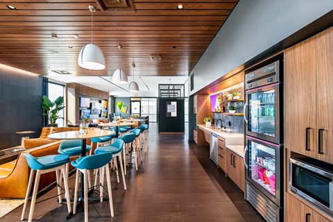 a dining room with tables and chairs and a kitchen